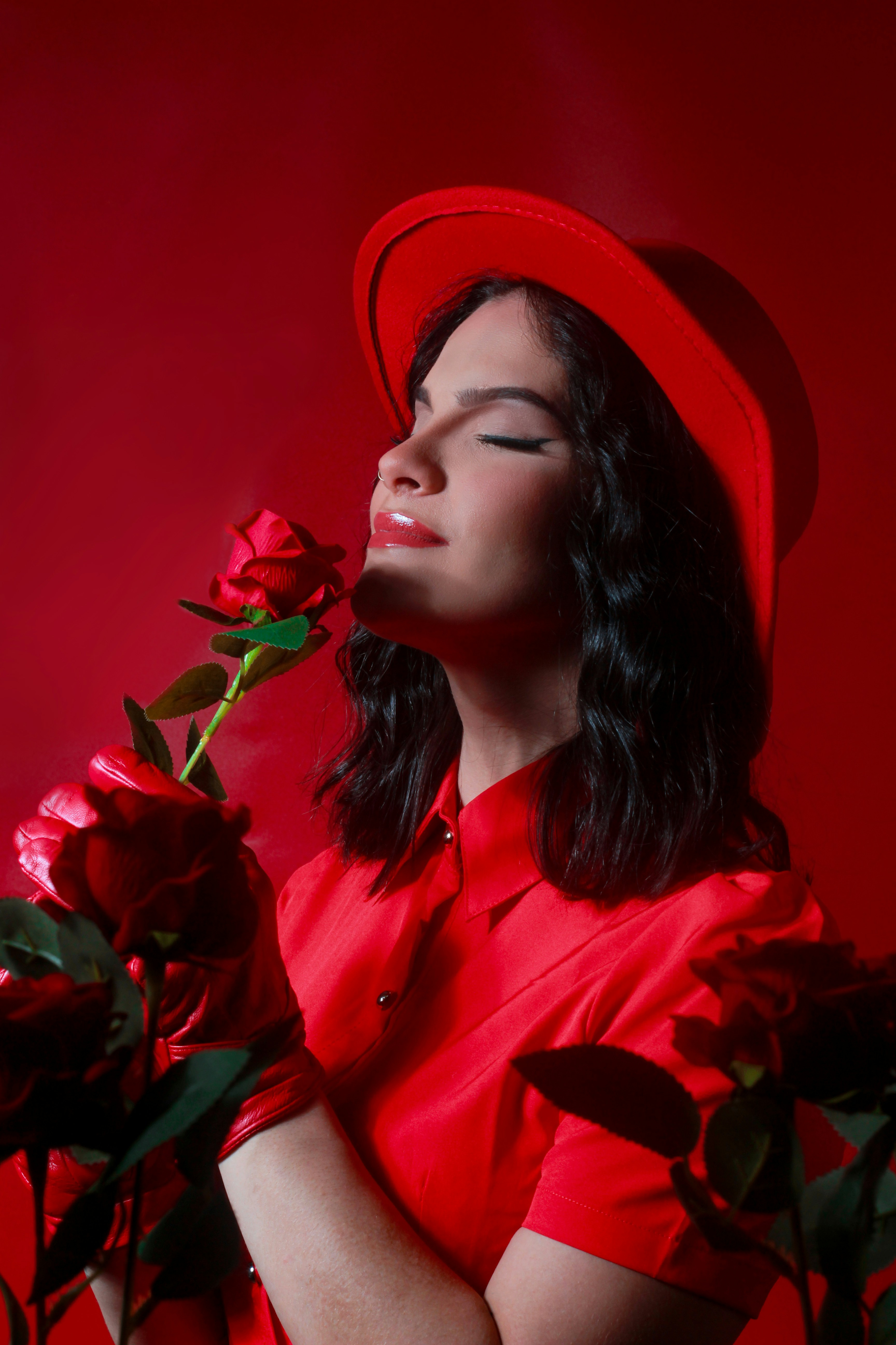 Frau im roten Kleid mit Rose und rotem Hut